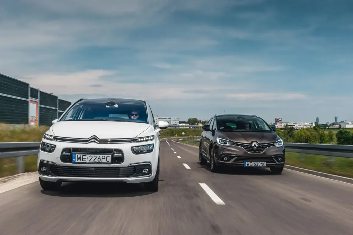 Biały Citroën C4 Grand Picasso i brązowy Renault Scenic jadą obok siebie drogą.