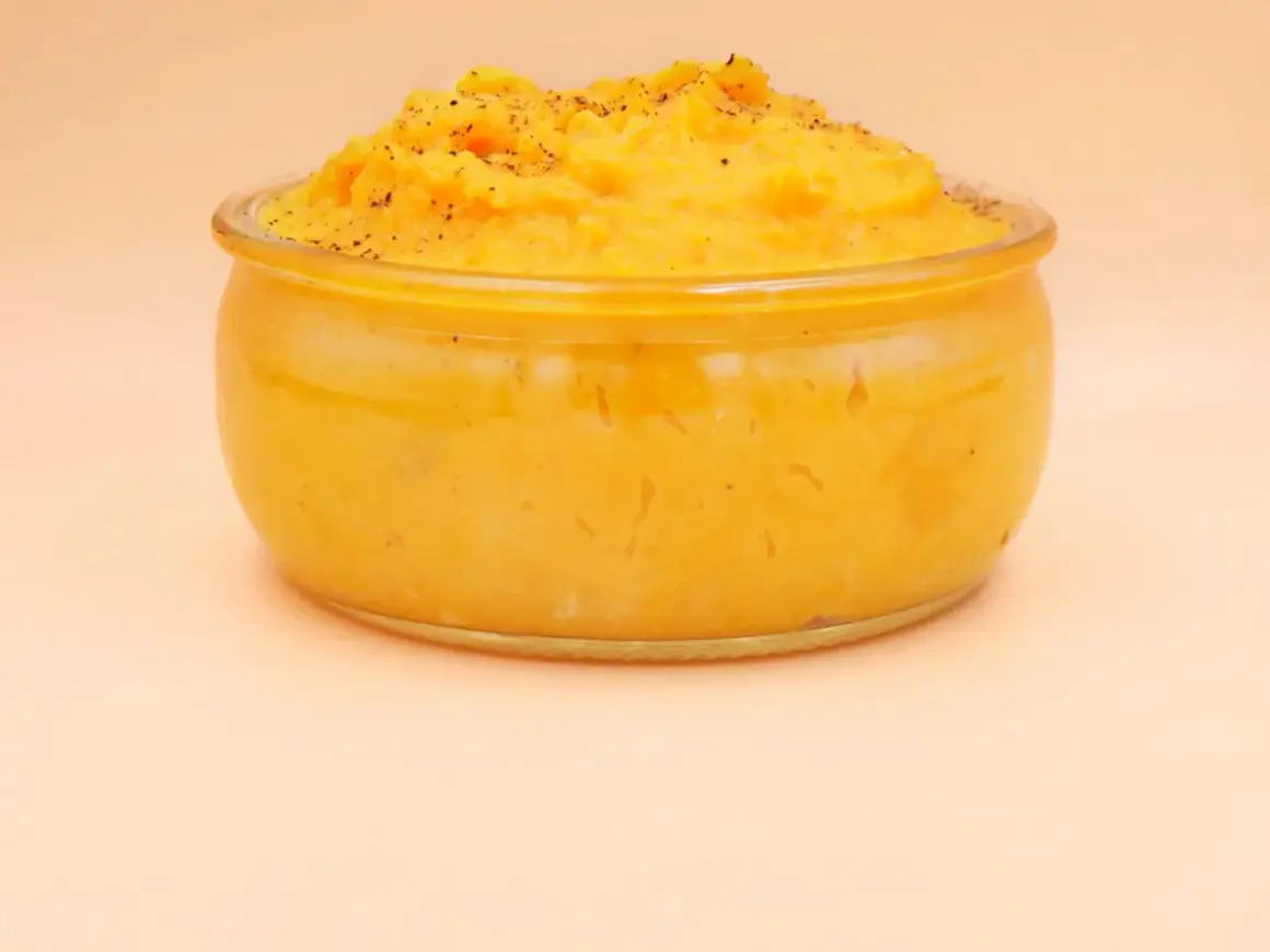 Pyszne, kremowe puree z batata w szklanym naczyniu, posypane świeżo mielonym pieprzem. Idealne jako dodatek do obiadu.