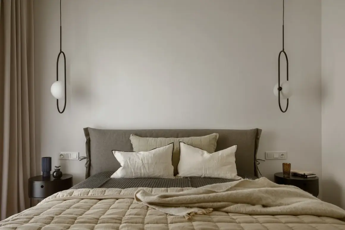 Sypialnia w stylu bauhaus z łóżkiem, poduszkami i minimalistycznymi lampami.