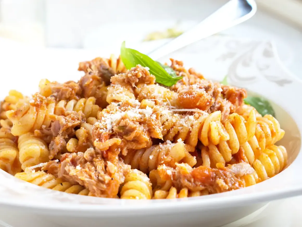 Fusilli-Pasta mit Thunfisch-Tomaten-Sauce, bestreut mit Parmesan. Ein köstliches Gericht, das zeigt, wie vielseitig Thunfisch-Rezepte sein können.