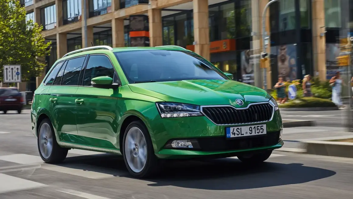 Grön Skoda Fabia kombi kör på stadsgata. Vissa modeller kan ha skoda fabia kamkedja problem.