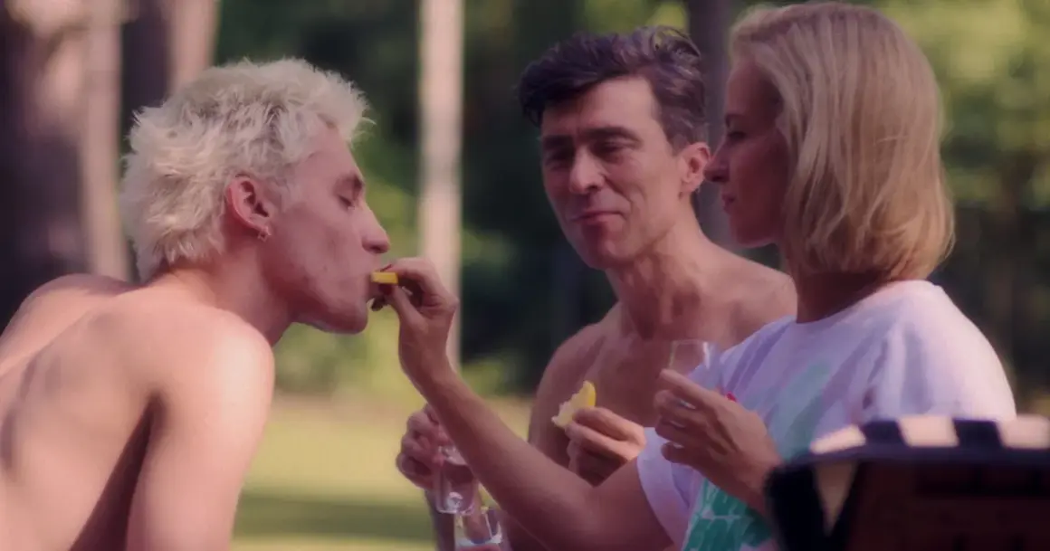 Trzy miłości film: blondyn z cytryną, mężczyzna wpatrzony w kobietę, która karmi blondyna.