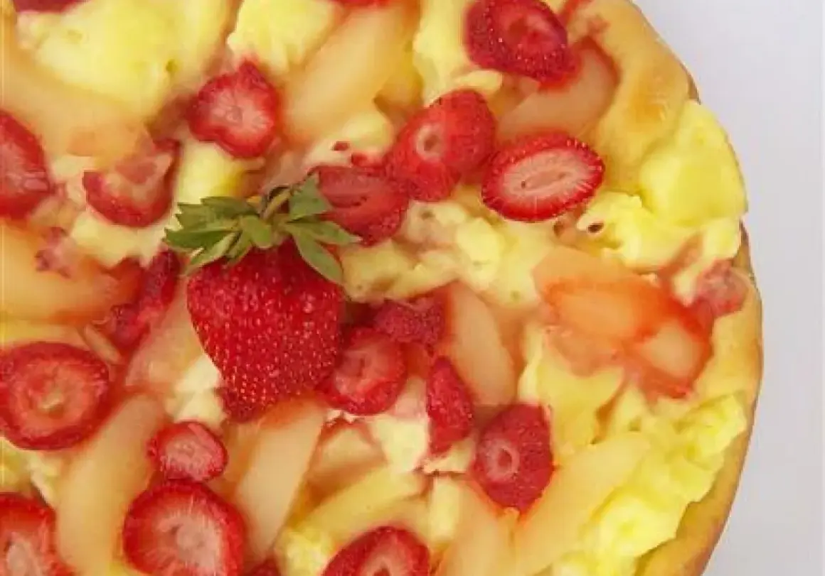 Słodka pizza z kremem budyniowym, truskawkami i kawałkami gruszek. Idealna na deser.