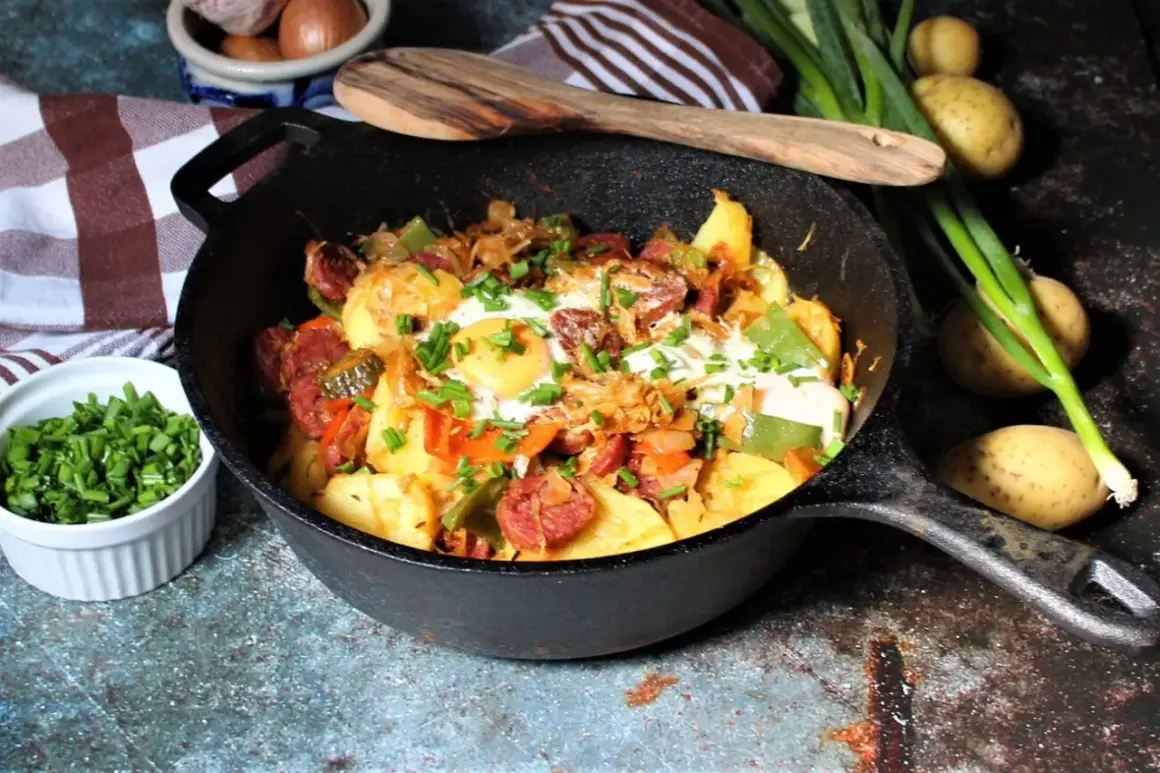 Herzhafte Bauernpfanne mit Ei, Kartoffeln, Wurst und Gemüse, garniert mit Schnittlauch. Ein deftiges Gericht für jeden Tag.