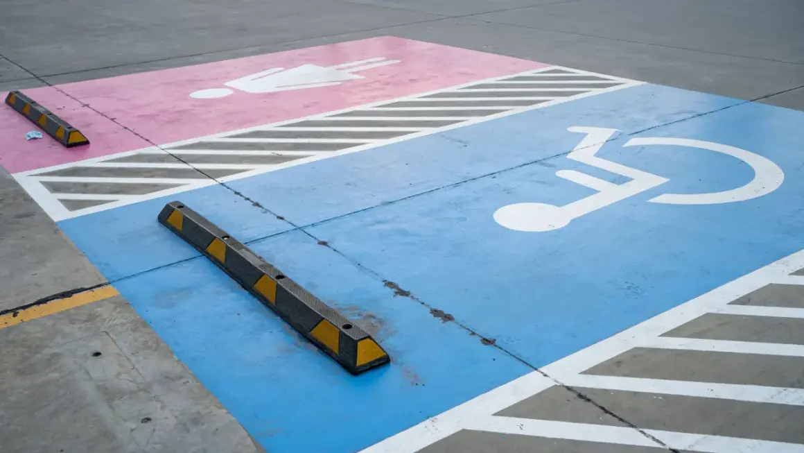 Niebieski pas z symbolem wózka inwalidzkiego i różowy z postacią ludzką. Czy parking dla niepełnosprawnych jest płatny?