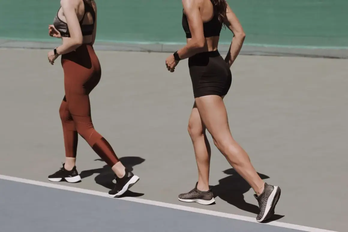 Deux femmes courent sur une piste, visant à marcher 8 km par jour pour leur entraînement.