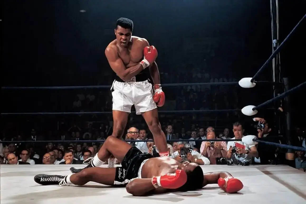 Iconic Muhammad Ali stands over a fallen opponent in the ring, a triumphant roar escaping his lips. A crowd watches, cameras flashing.
