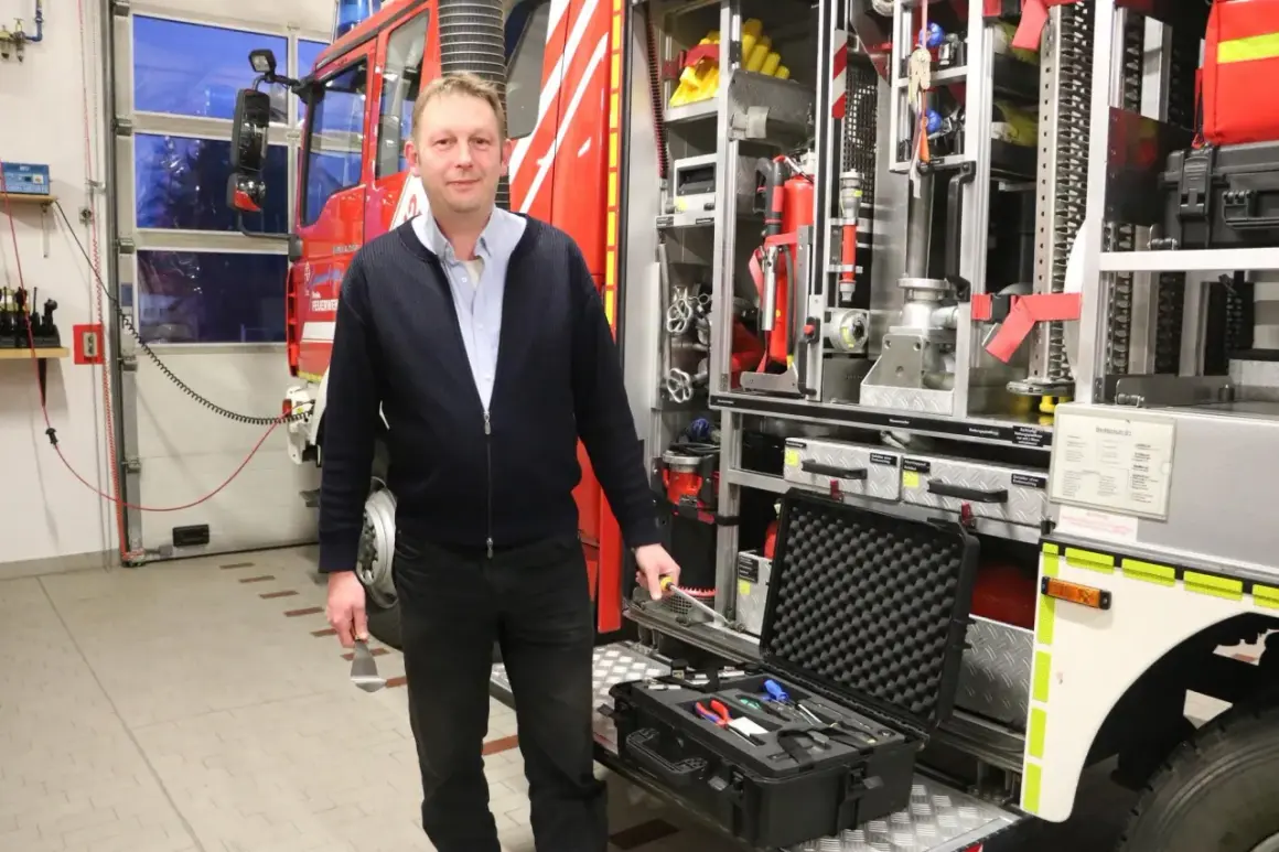 Mann vor Feuerwehrfahrzeug mit Werkzeugkoffer. Tolle Feuerwehr mitgliederwerbung ideen für Nachwuchs.