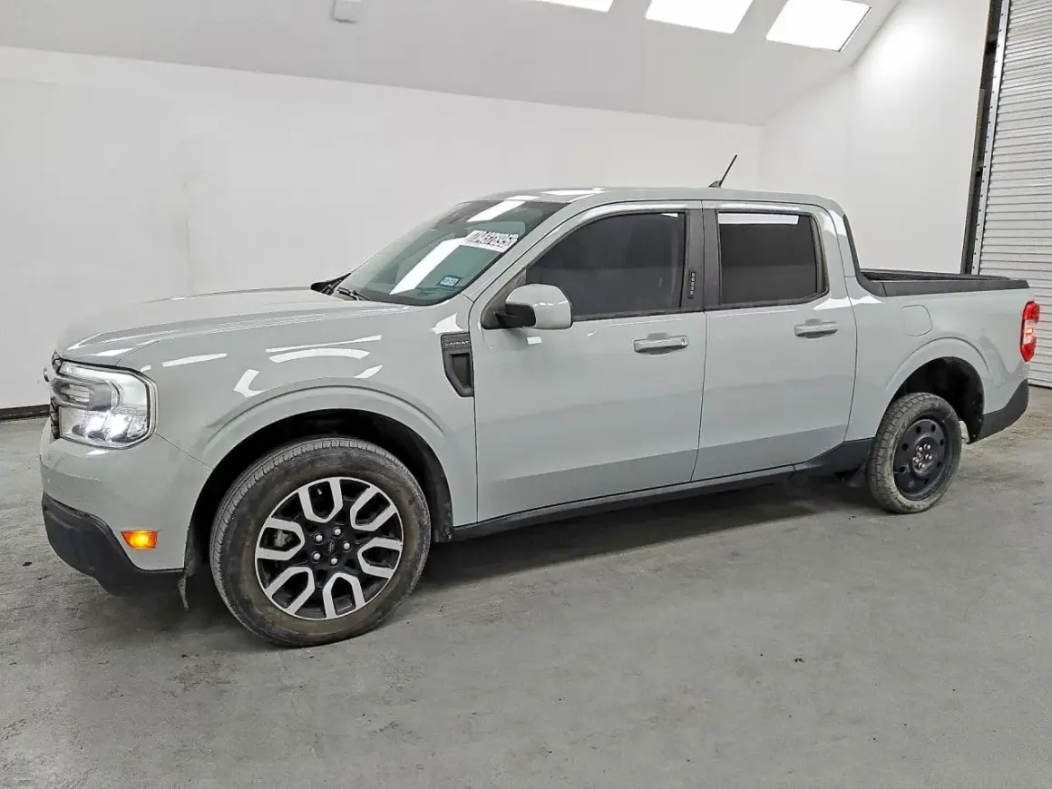 Szary Ford Maverick, kompaktowy pickup, stoi w garażu. Jego linia nadwozia jest nowoczesna, a przednie światła LED nadają mu charakterystyczny wygląd.