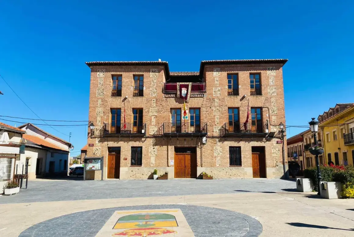 Ayuntamiento de ladrillo en plaza soleada, ideal para descubrir pueblos con encanto para comer cerca de Madrid.