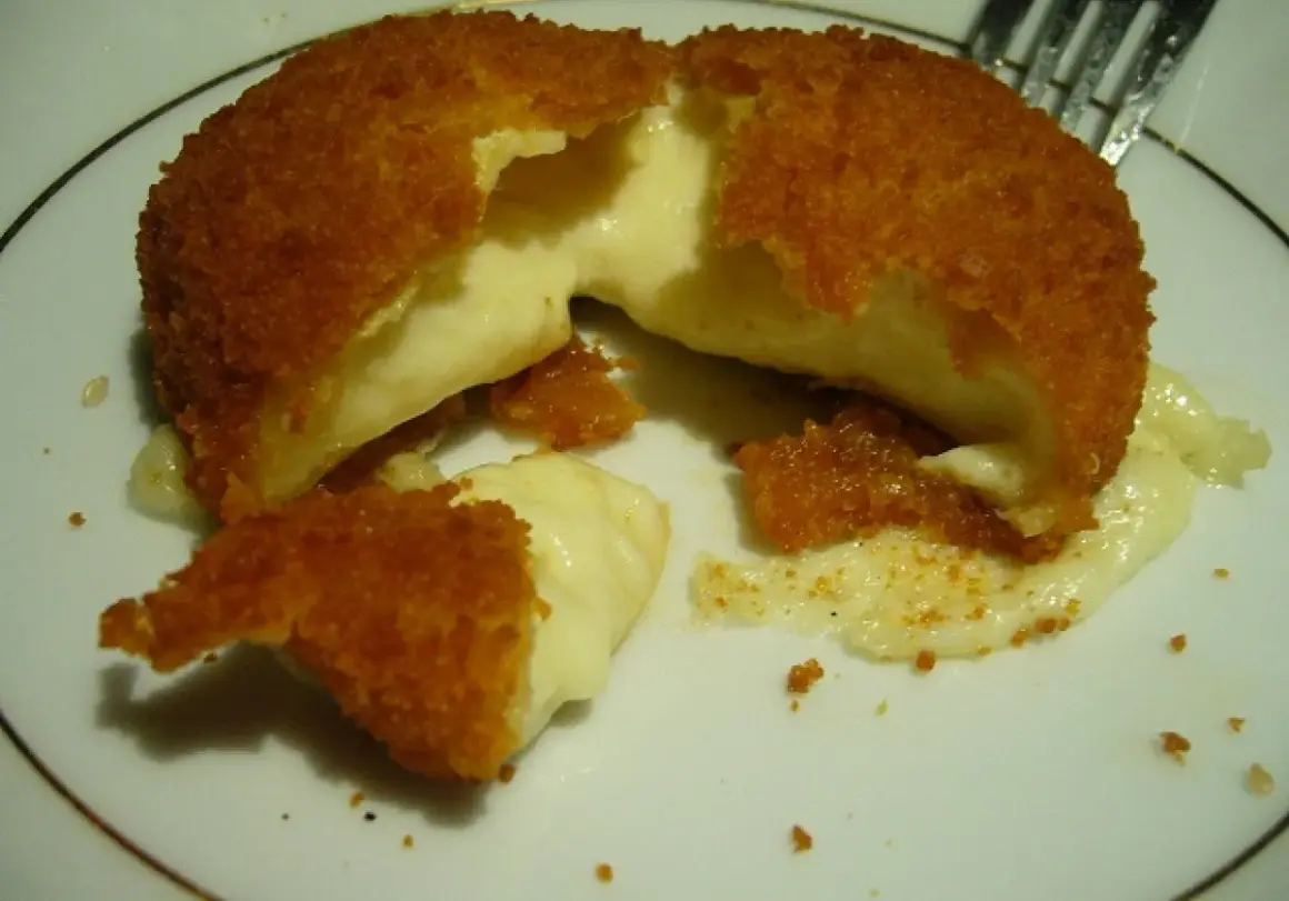 Pyszny camembert w panierce, z którego wypływa gorący, ciągnący się ser. Idealna przekąska na ciepło.