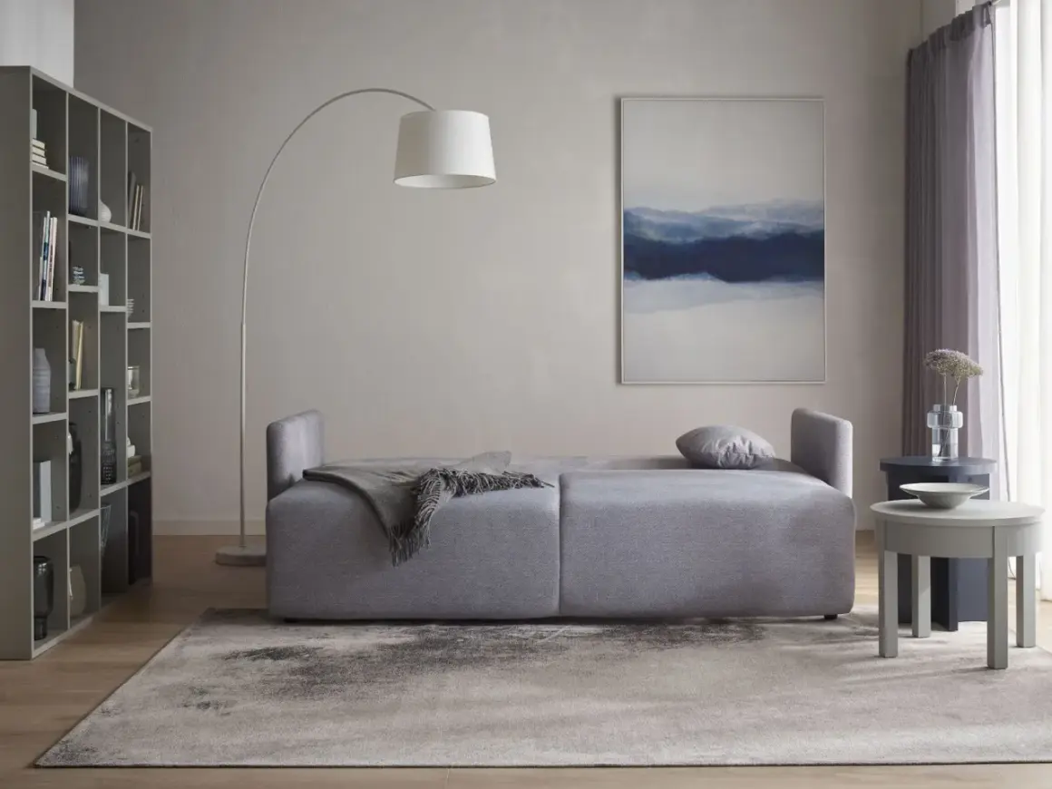 Jasne ściany idealnie komponują się z szarymi meblami, tworząc spokojną i elegancką przestrzeń.