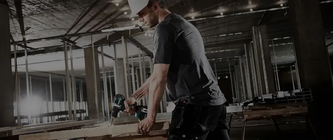 Un ouvrier utilise une perceuse Makita sur un chantier. Il est important d'enregistrer votre garantie Makita non enregistrée pour une protection optimale.