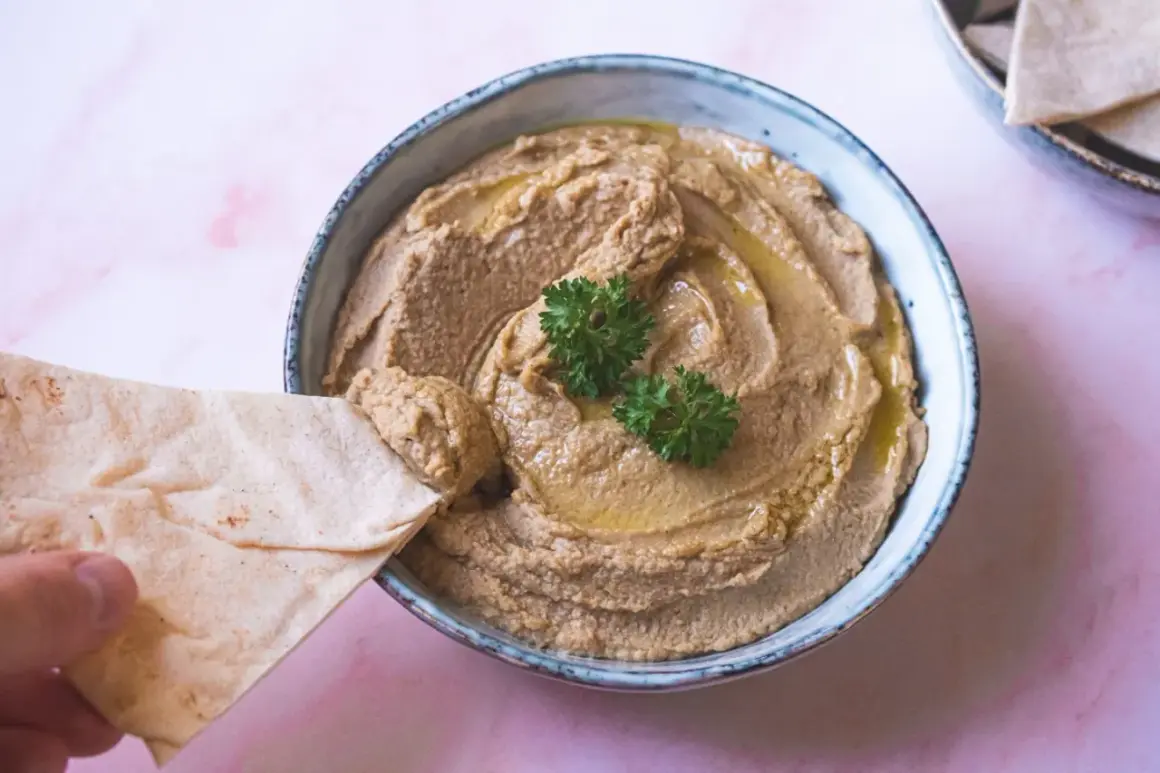 Krämig hummus utan tahini, perfekt att dippa pitabröd i. Garnerad med persilja och olivolja.