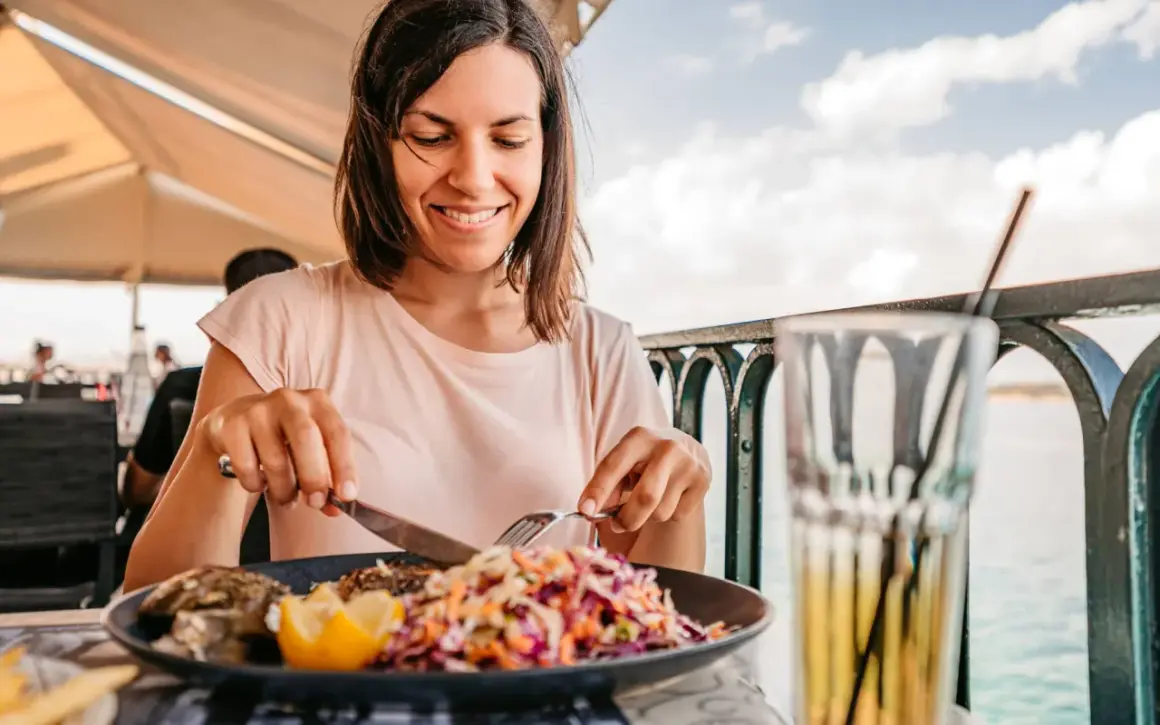 Frau genießt Fisch mit Salat, eine Mahlzeit, die gut zur pescetarier bedeutung passt.