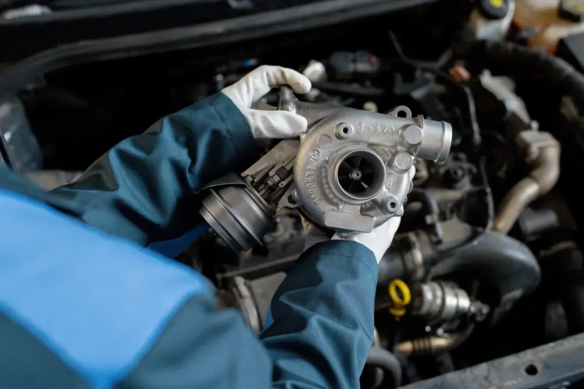 Mechanik w białych rękawiczkach trzyma turbosprężarkę, gotową do montażu, by zapewnić podwójną moc silnika dzięki twin power turbo.