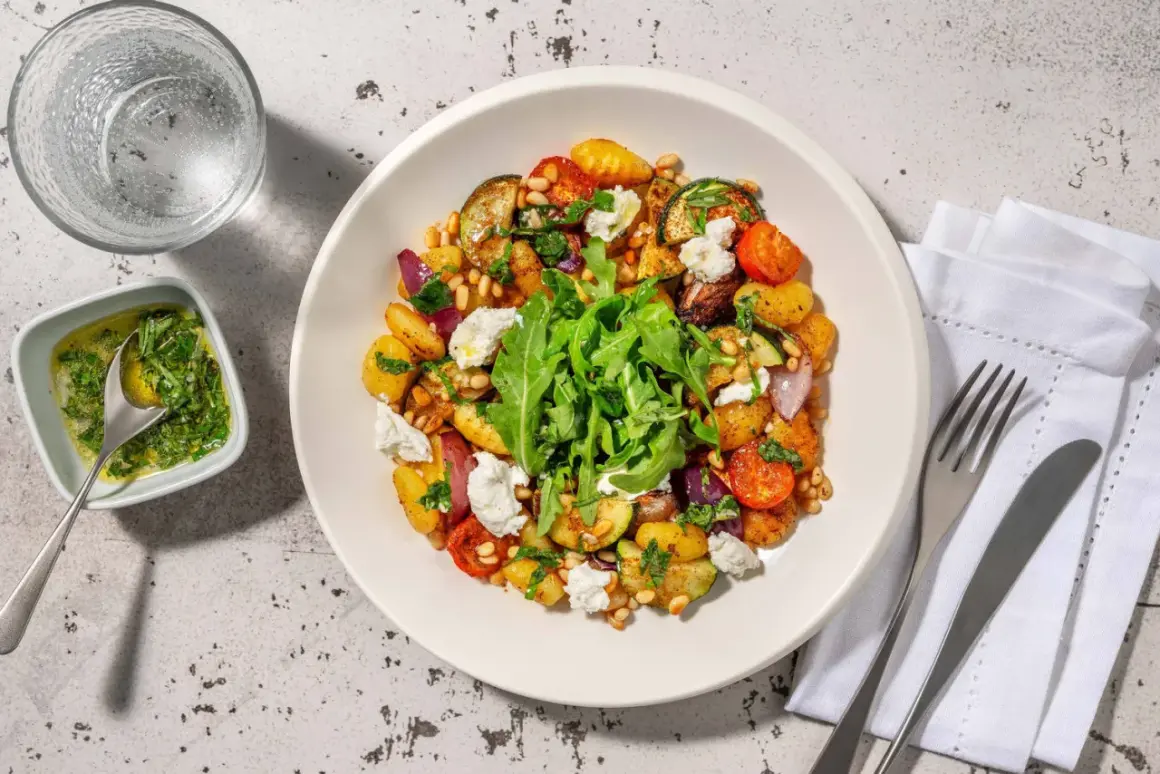 En härlig ugnsrostad grönsaksrätt med potatis, zucchini, tomater och lök, toppad med ricotta och pinjenötter. Ett perfekt ricotta recept för en lätt middag.
