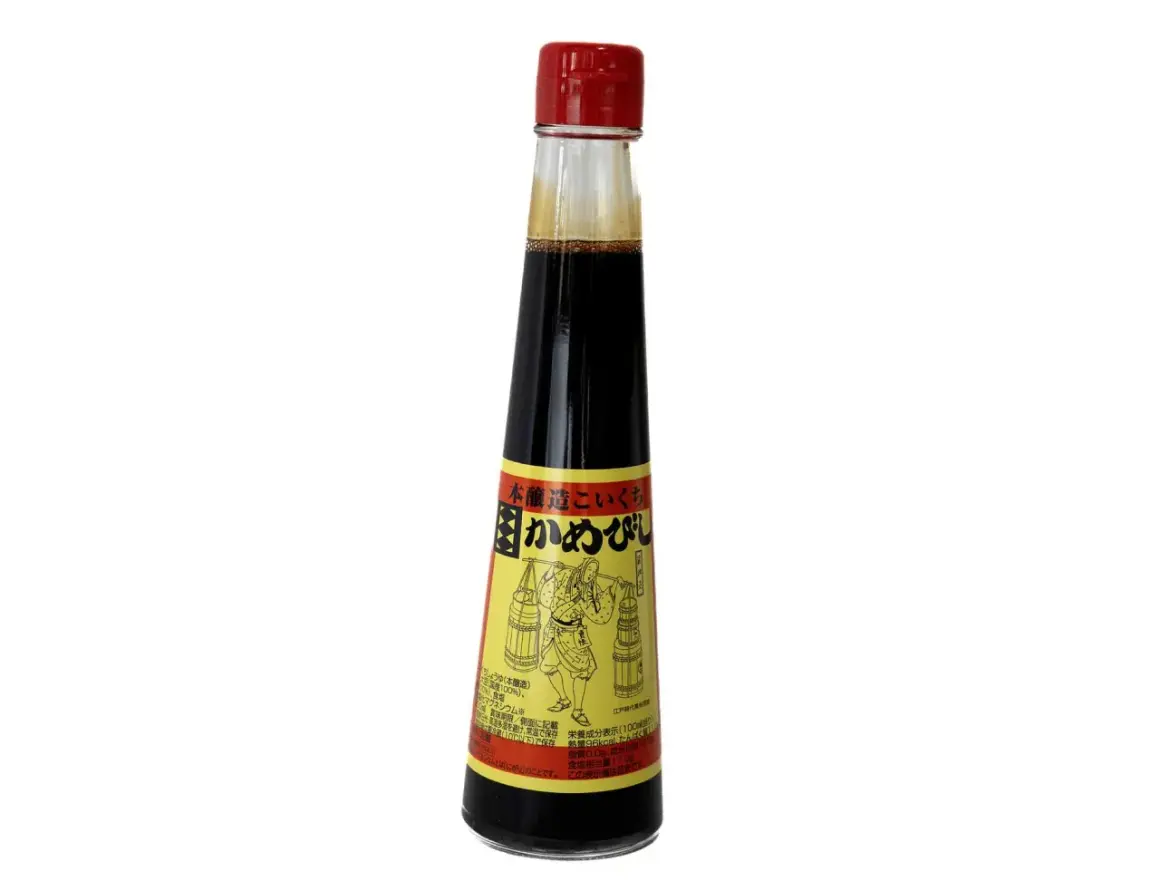 En flaska mörk sojasås med en röd kork. Etiketten visar en figur som bär korgar, vilket antyder att soja kan bli gammal och utveckla smak.
