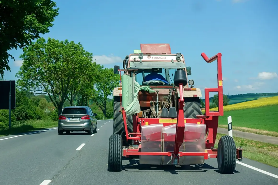 Ein Traktor mit Ballenwickler fährt langsam auf der Autobahn. Ein Auto dahinter gibt Lichthupe, um zu überholen.