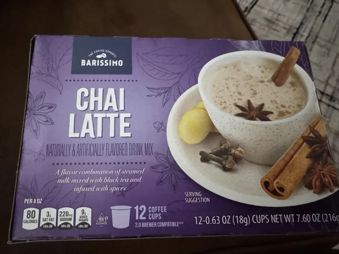 En låda Barissimo Chai Latte med en bild av en kopp chai latte. Lådan beskriver vad som innehåller chai latte: en blandning av ångad mjölk, svart te och kryddor.