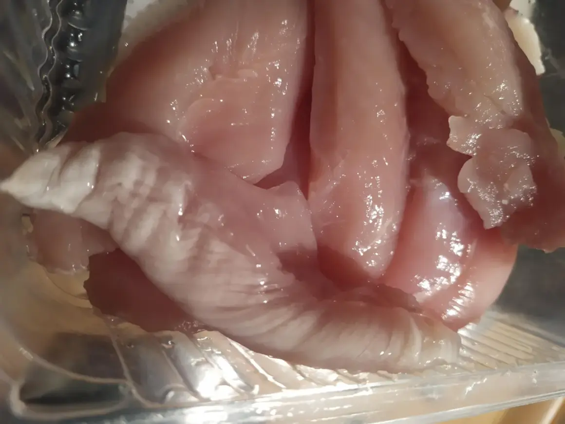 Rå kycklingfiléer i en plastförpackning. Ser inte aptitligt ut, undrar hur smakar dålig kyckling.