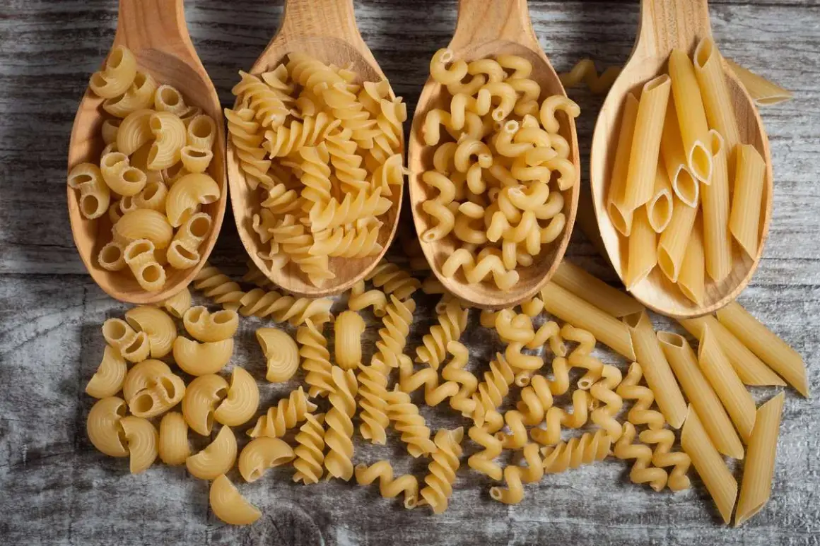 Vier Holzlöffel mit verschiedenen Nudelsorten: Maccheroni, Fusilli, Cavatappi und Penne. Eine Frage, wie viel Gramm Fusilli pro Person?