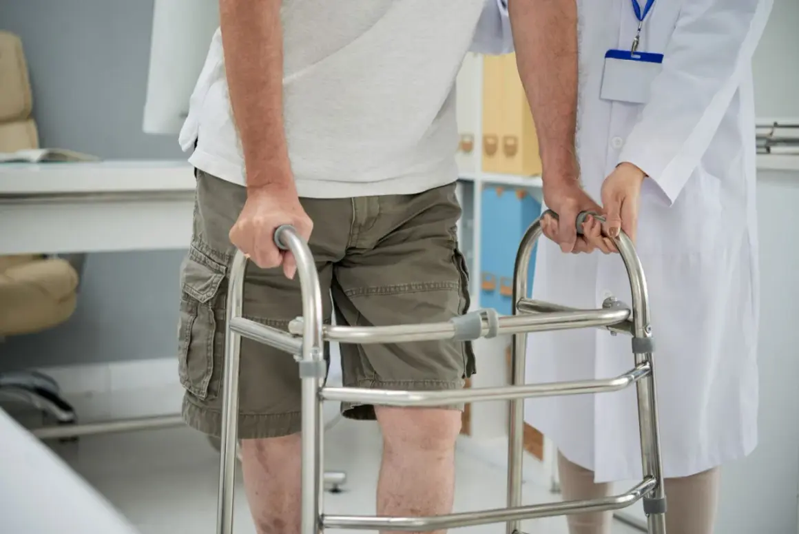 Un uomo anziano, con una sensazione di camminare storto, si appoggia a un deambulatore mentre un medico lo assiste.