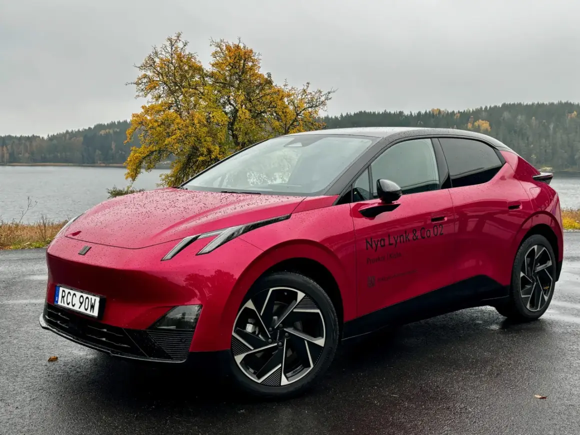 Röd elbil parkerad vid en sjö med höstfärger. En perfekt plats för en tco kalkyl.