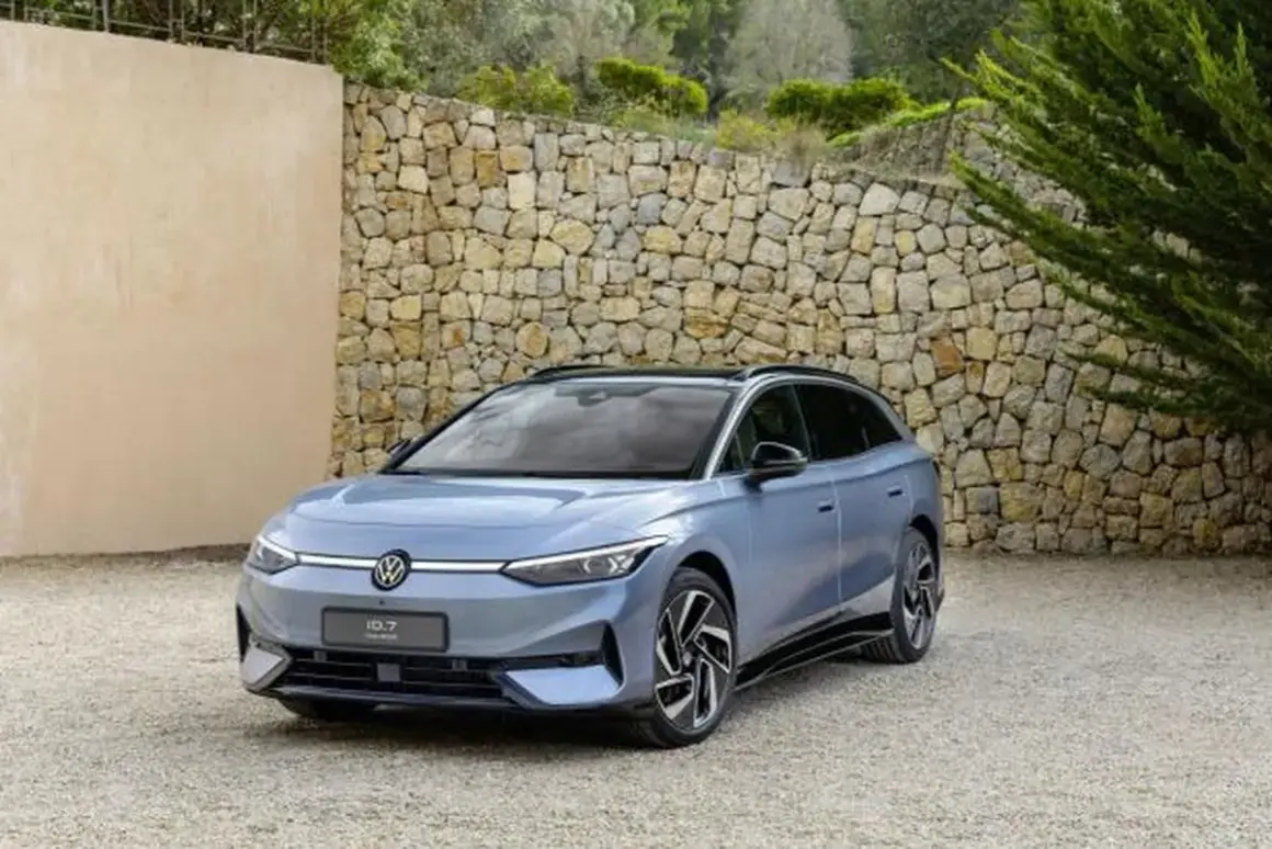 Niebieski Volkswagen ID.7, następca Passata, zaparkowany przed kamiennym murem.