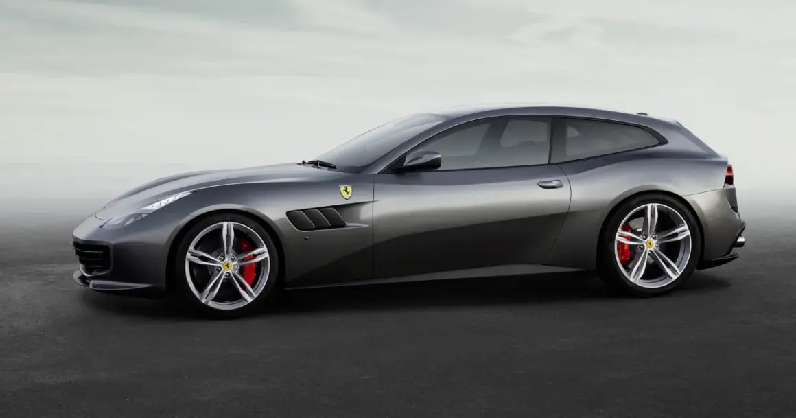 Szary Ferrari FF, sportowe kombi z charakterystycznymi wlotami powietrza i czerwonymi zaciskami hamulcowymi, prezentuje się na tle mglistego nieba.
