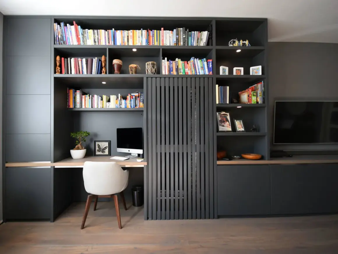 Gemütliche arbeitsecke im wohnzimmer mit Schreibtisch, Computer und Bücherregal.