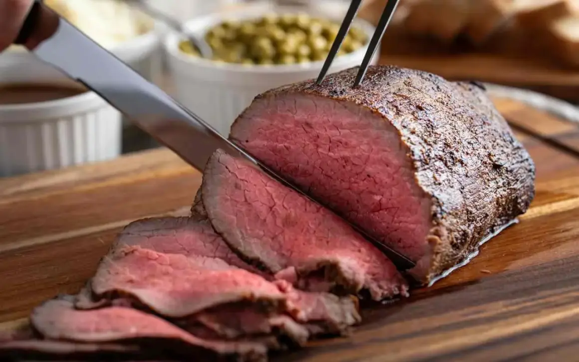 Roast beef succulento affettato, pronto per essere gustato. Una perfetta roast beef ricetta in pentola per un pranzo speciale.