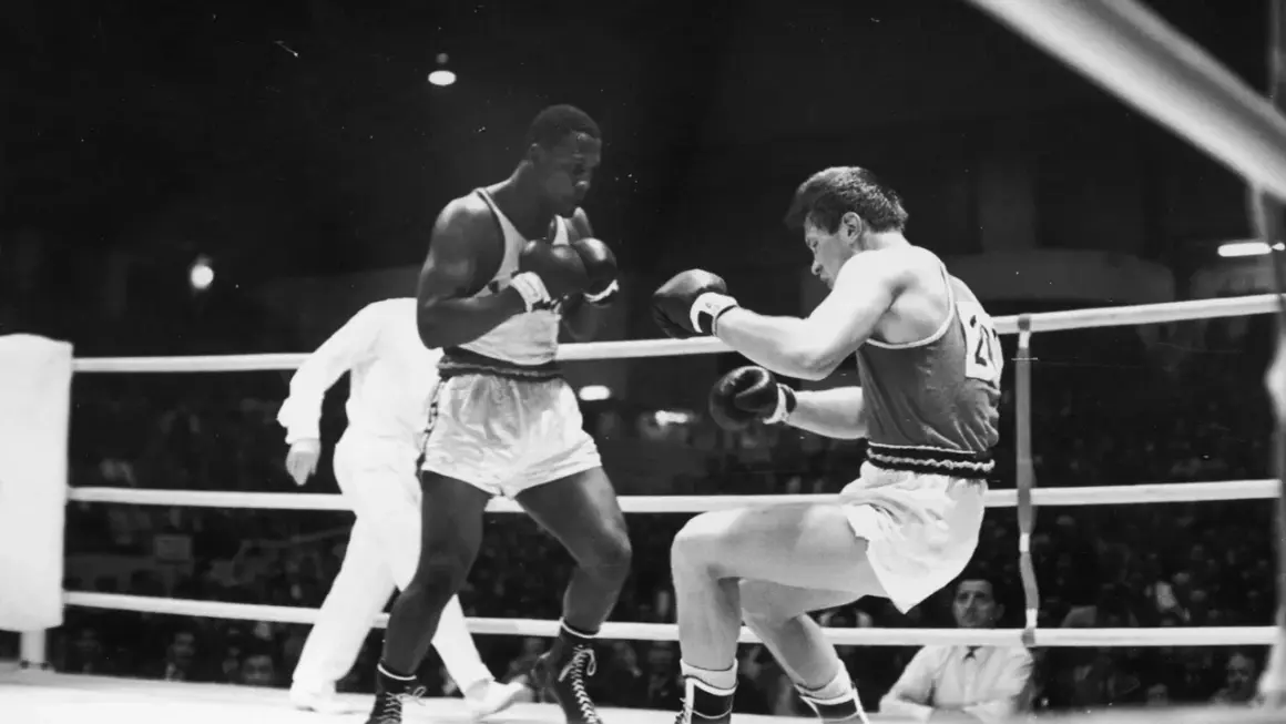 Young Joe Frazier in a boxing match, focused and ready to fight.