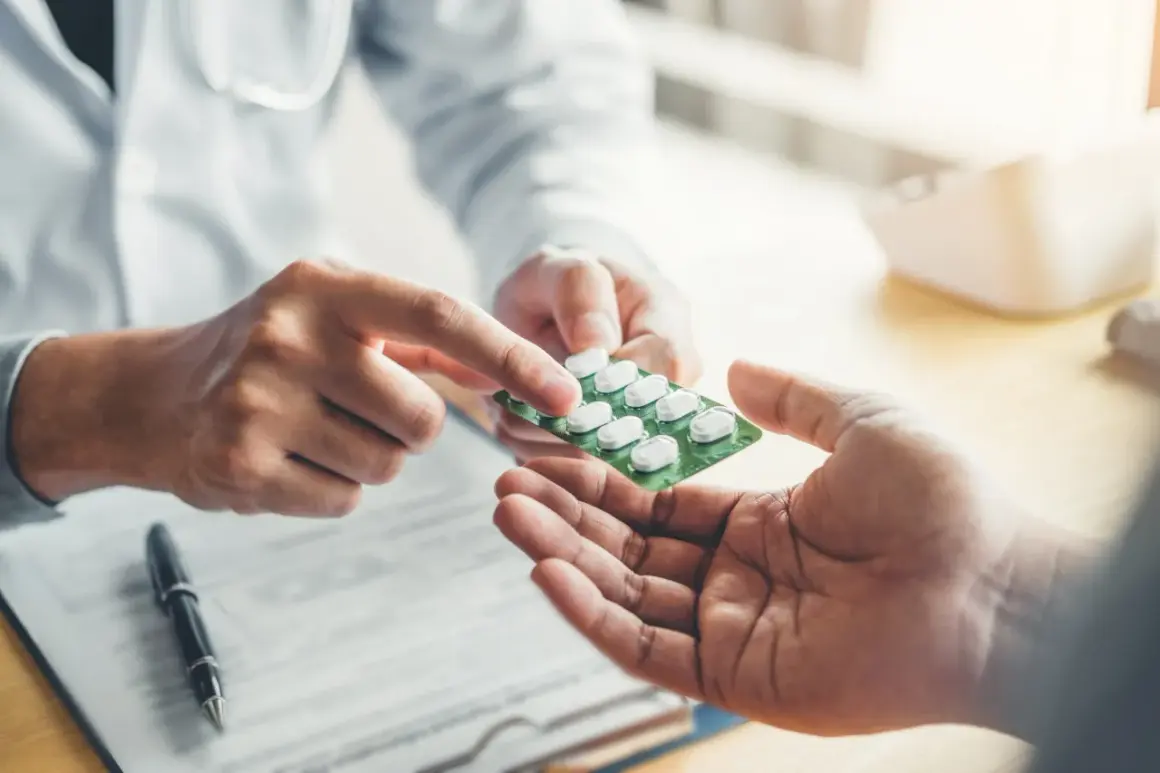 Lekarz podaje pacjentowi opakowanie tabletek. Sprawdź aktualną xarelto 20 mg cena.