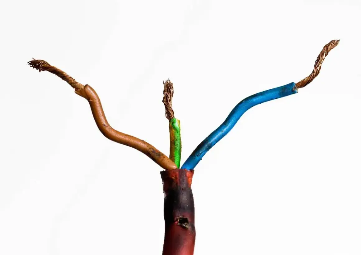 Beschädigte Kabel mit freiliegenden Drähten, die auf einen möglichen kabelbrand geruch hindeuten. Die Isolierung ist an einer Stelle geschmolzen.