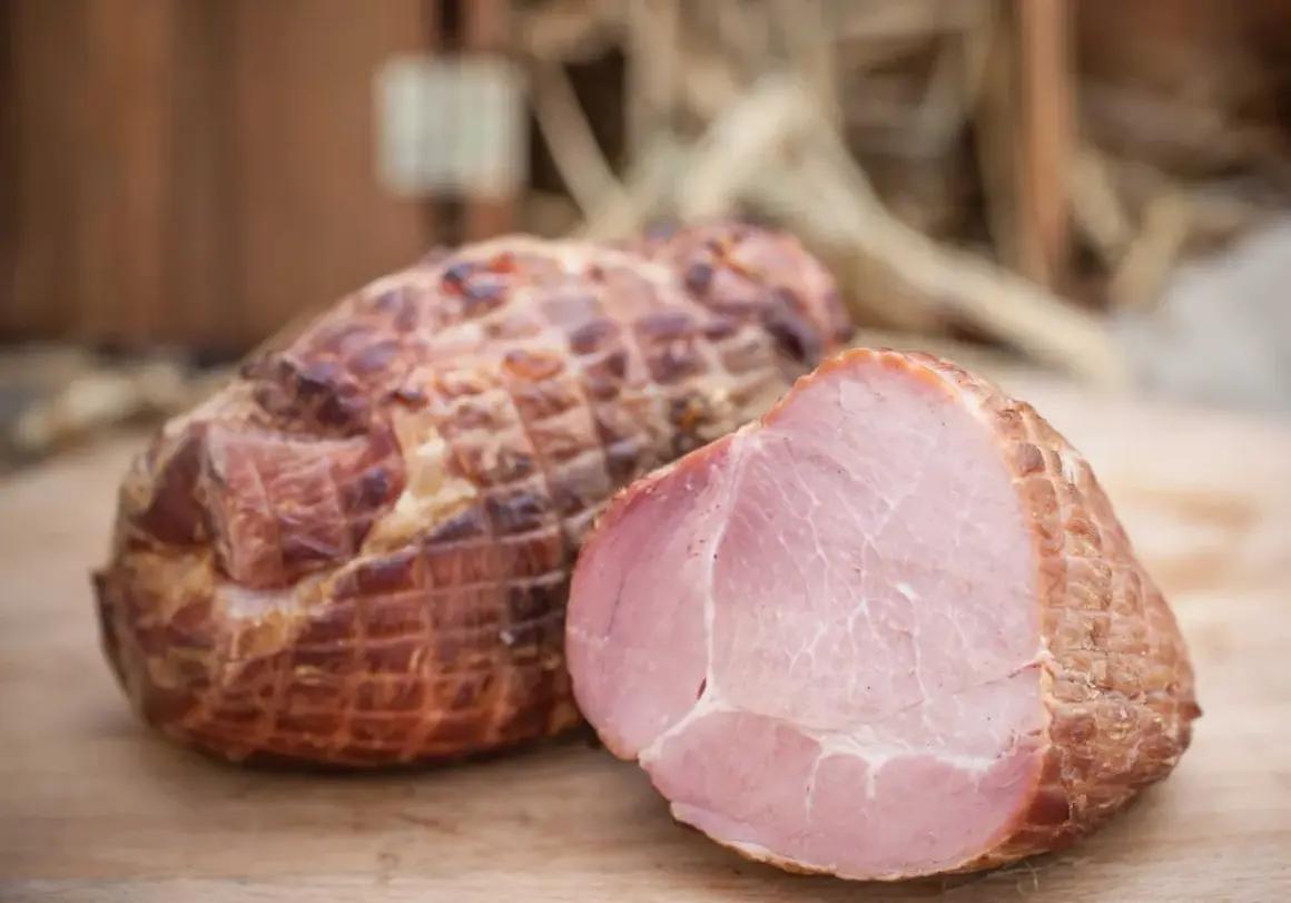 Wędzonka po peklowaniu na sucho próżniowo. Jedna sztuka przekrojona, ukazująca soczyste, różowe mięso.