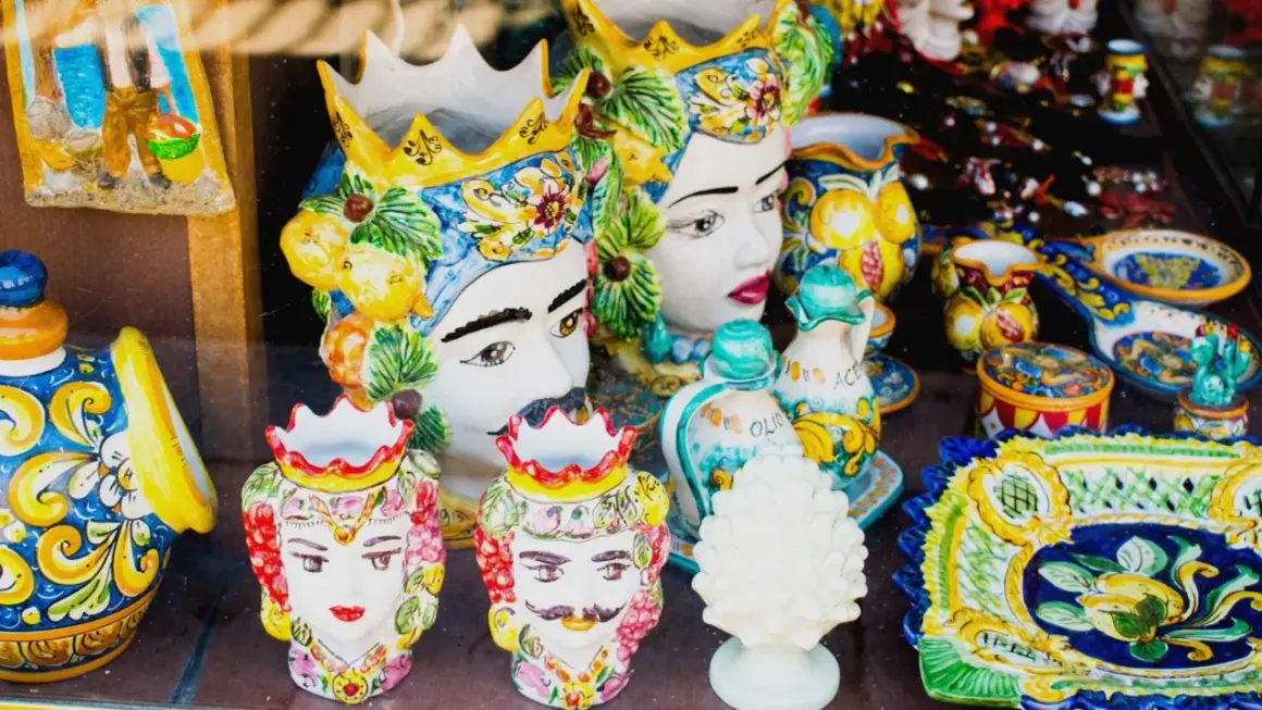 Ceramiche siciliane con teste di moro, vasi decorati e piatti colorati, un'esplosione di arte che ricorda il fascino di Palermo.