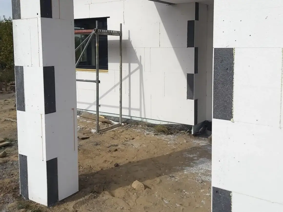 Budowa domu z bloczków styropianowych. Widać, jak kleić styropian do styropianu, tworząc solidną konstrukcję.