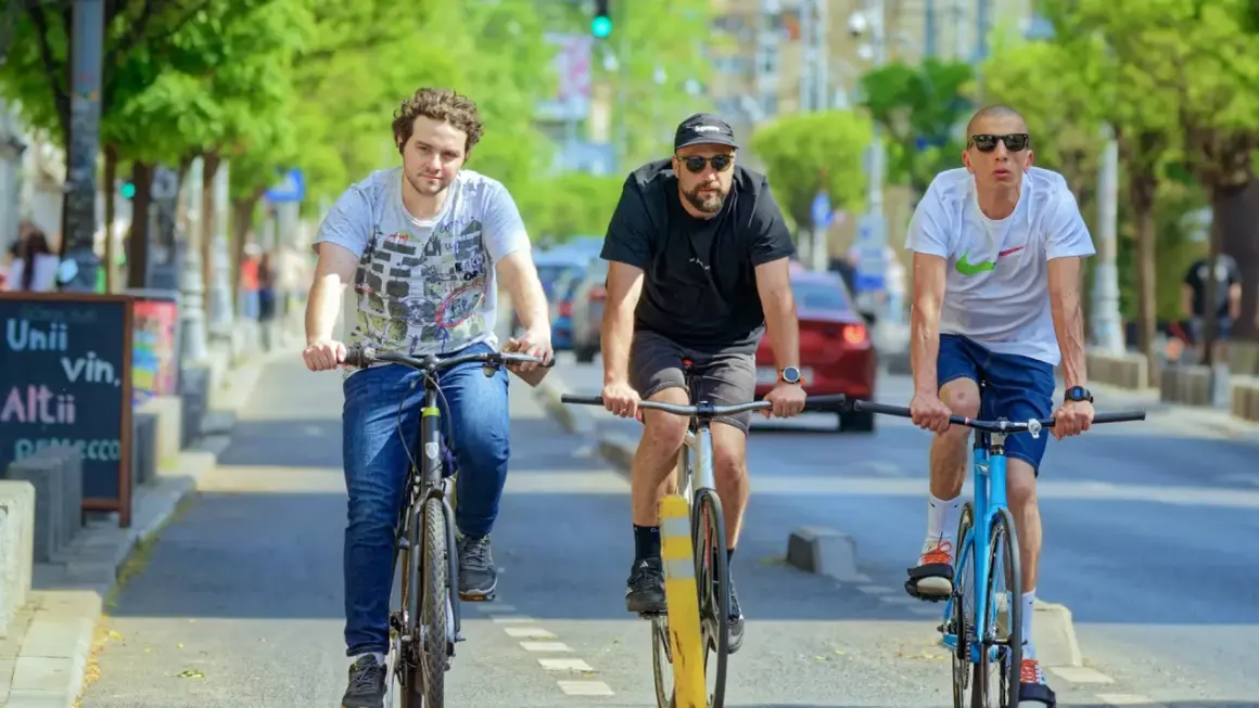 Drei Freunde fahren nebeneinander Fahrrad auf einer Straße.