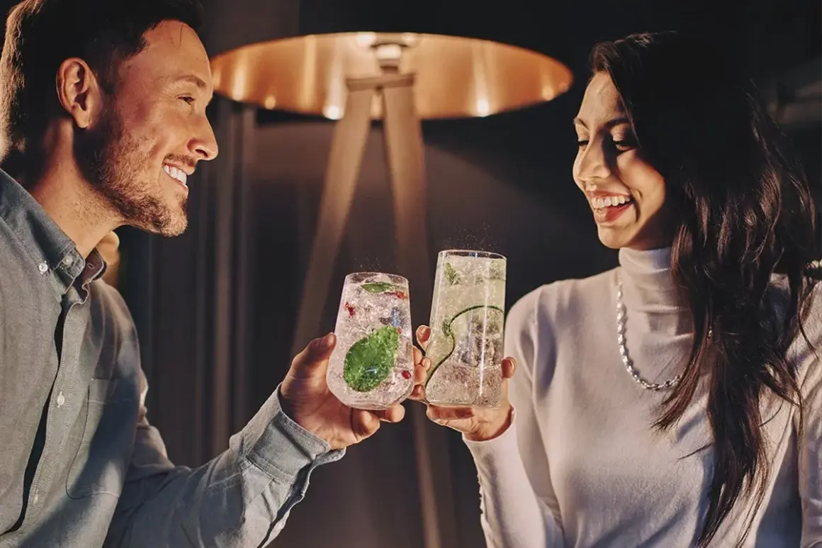Para wznosi toast drinkami, szukając inspiracji na białystok atrakcje dla par.