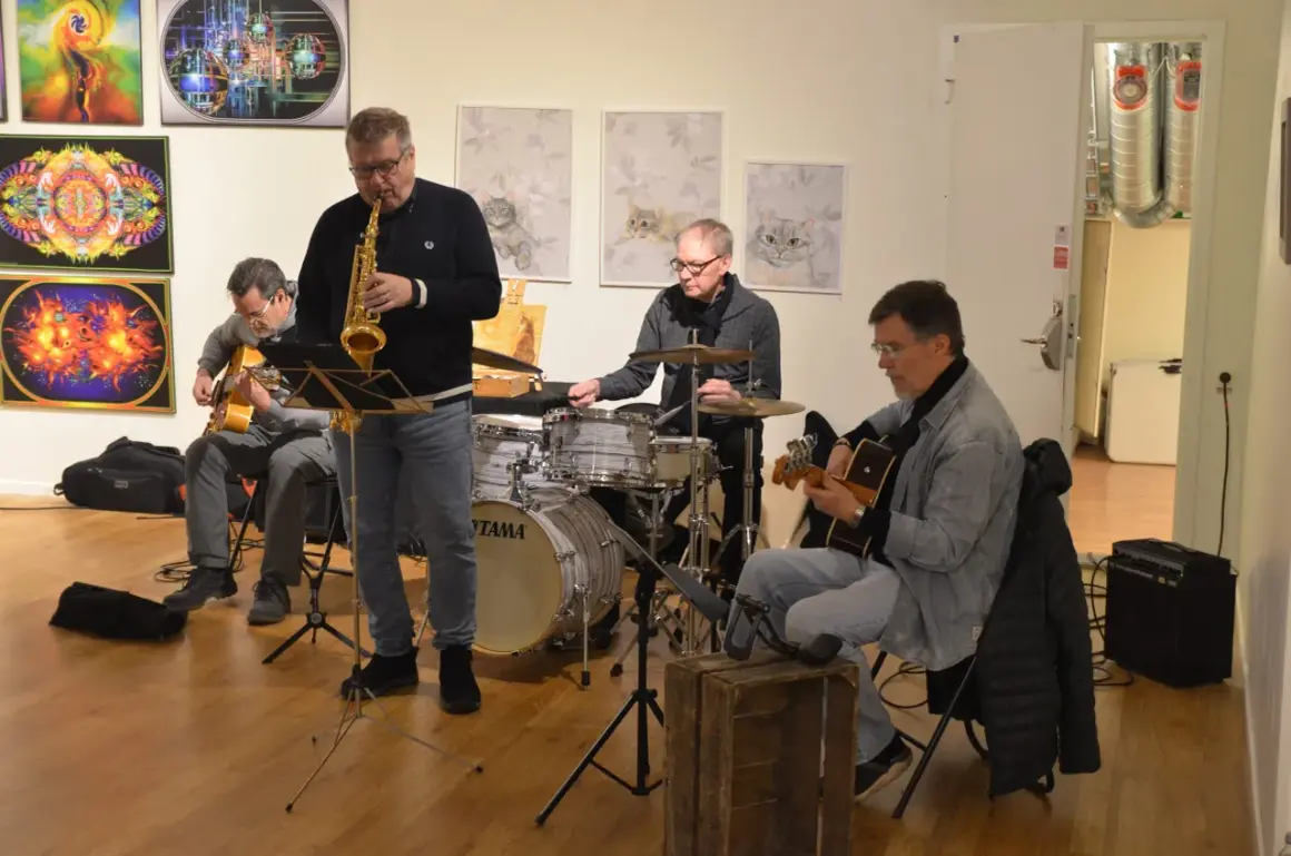 Jazzband spelar i galleri med konst av Kerstin Bengtsson Norén. Saxofonist, gitarrist och trummis.