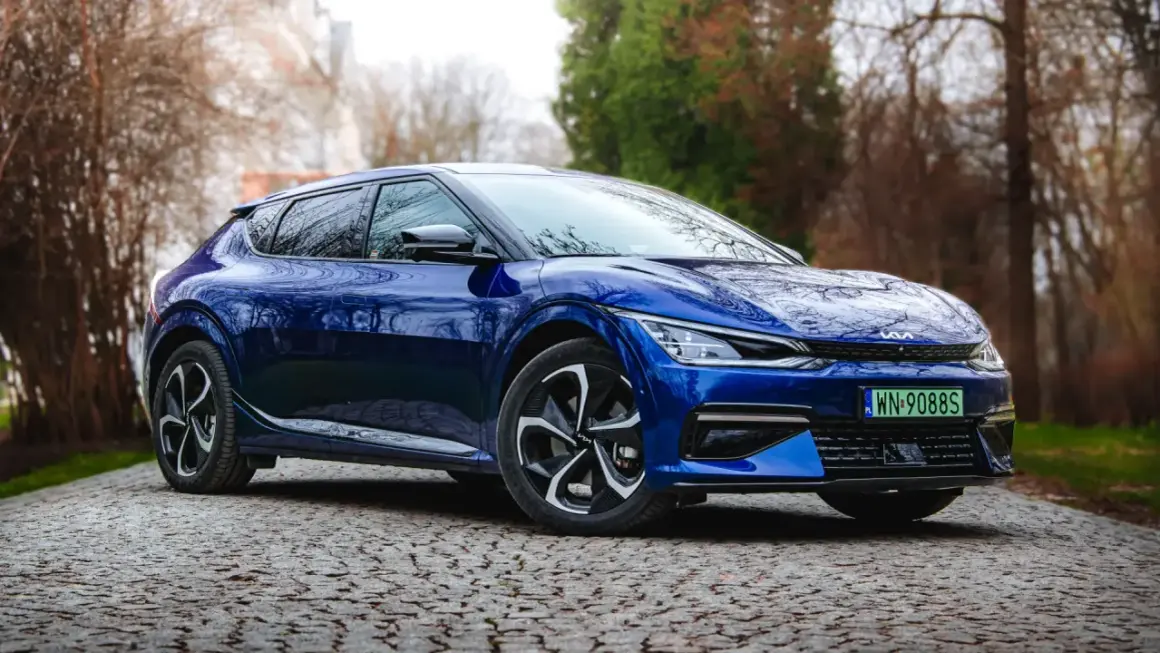 Niebieska Kia EV6 na kamienistej drodze, gotowa do testu. Elegancki design i nowoczesna technologia.
