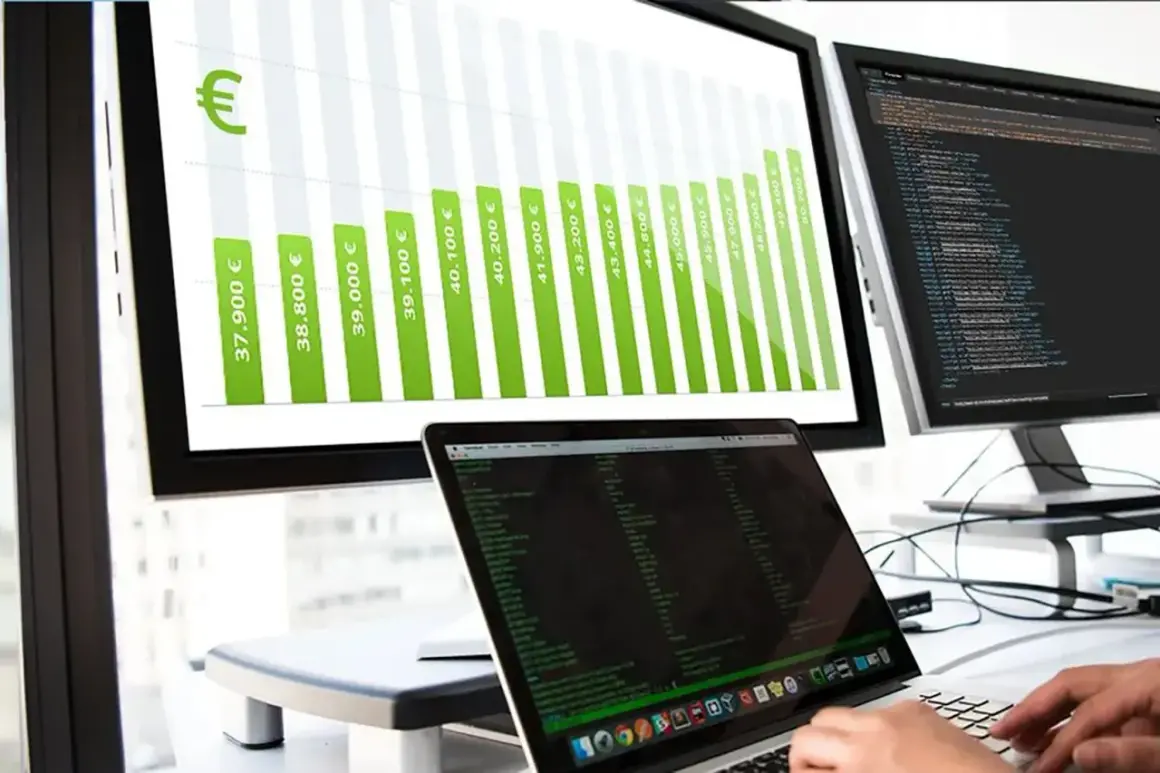 Balkendiagramm zeigt steigende Gehälter für Informatiker, von 37.900 € bis über 50.000 €. Ein Laptop mit Code ist im Vordergrund zu sehen.
