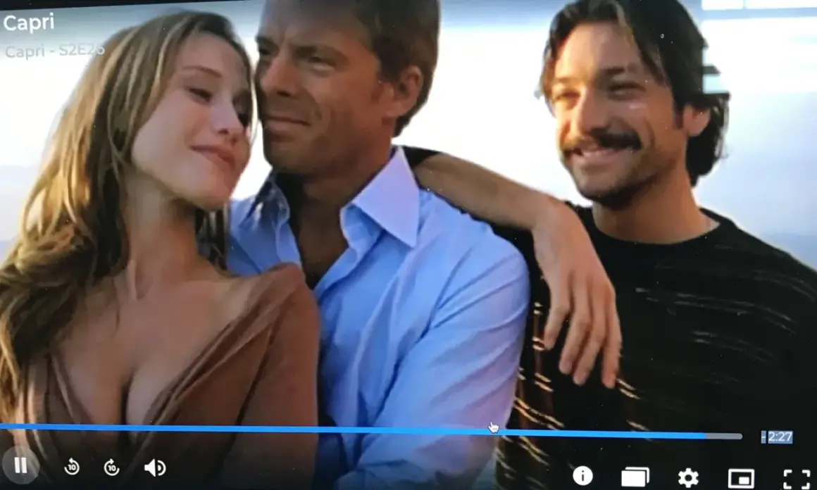 Il cast di Capri - S2E26: una donna bionda tra due uomini, uno con camicia azzurra, l'altro con maglia a righe.