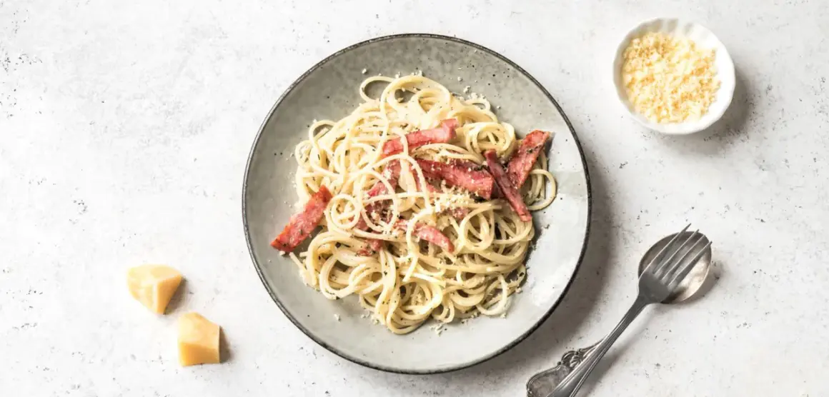Ein Teller Spaghetti Carbonara mit Speck und Parmesan. Perfekt für die Frage: welcher Wein zu Carbonara.