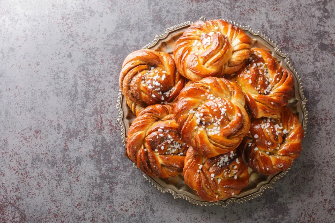 En bricka med nybakade kanelbullar, perfekta att baka i varmluftsugn. Strösslade med pärlsocker.