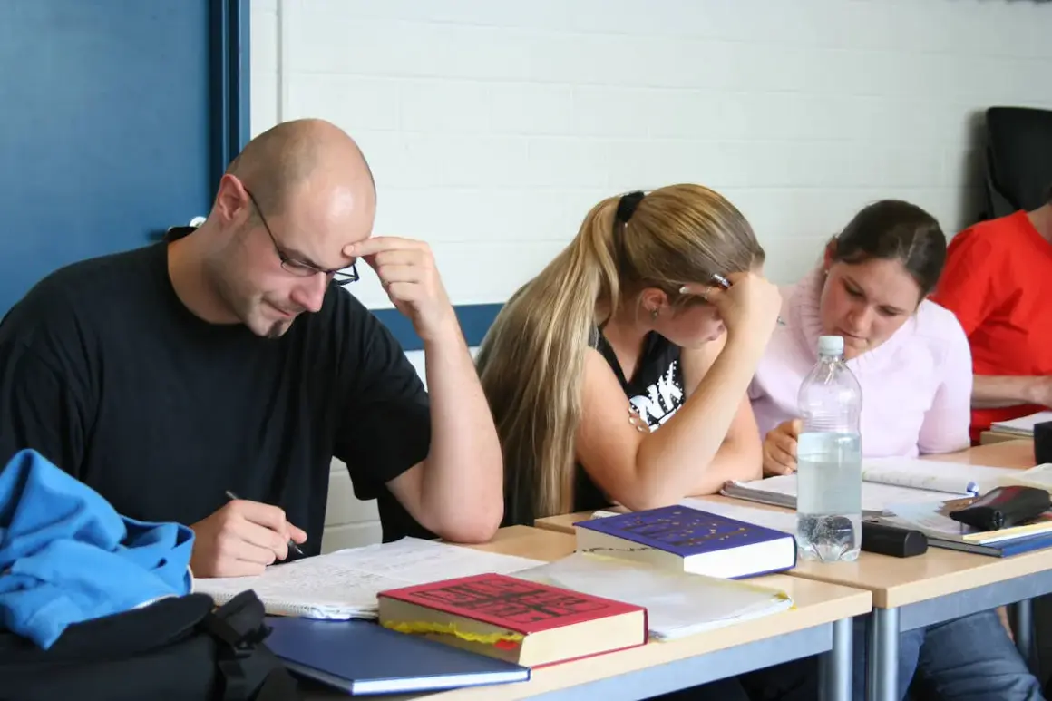 Konzentrierte Studierende beim lateinischen Fernstudium, vertieft in ihre Unterlagen.