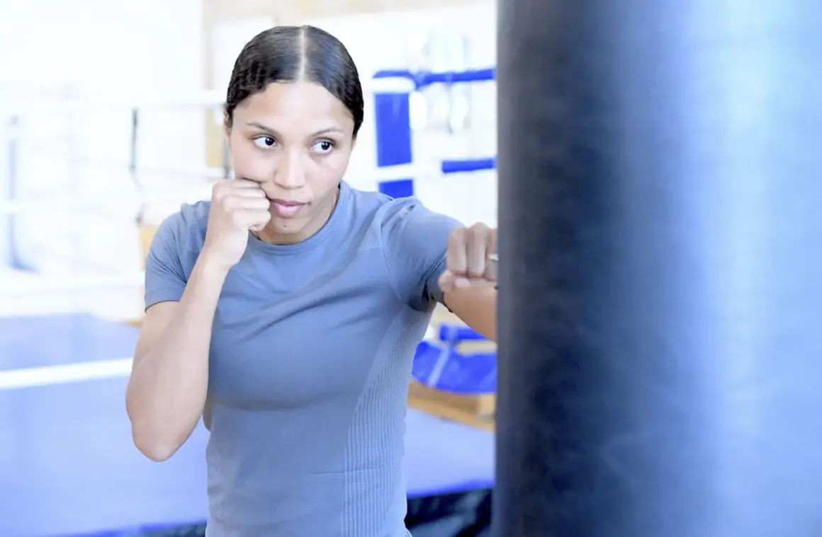 Agnes Alexiusson tränar boxning och slår mot en sandsäck i en gymmiljö.