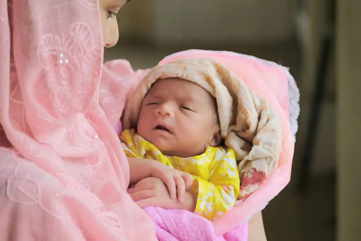 Une mère câline son nouveau-né, enveloppé dans des tissus roses et crème. Une douce image pour des douces félicitations naissance islam.