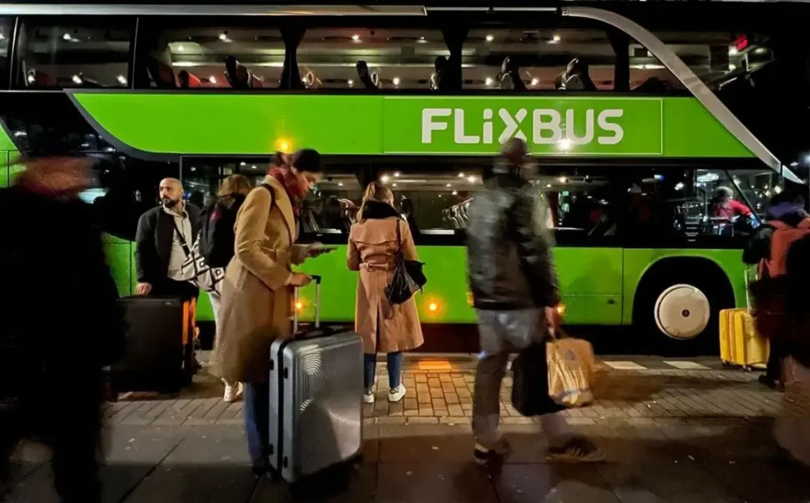 Ludzie z bagażem czekają na zielonego Flixbusa.